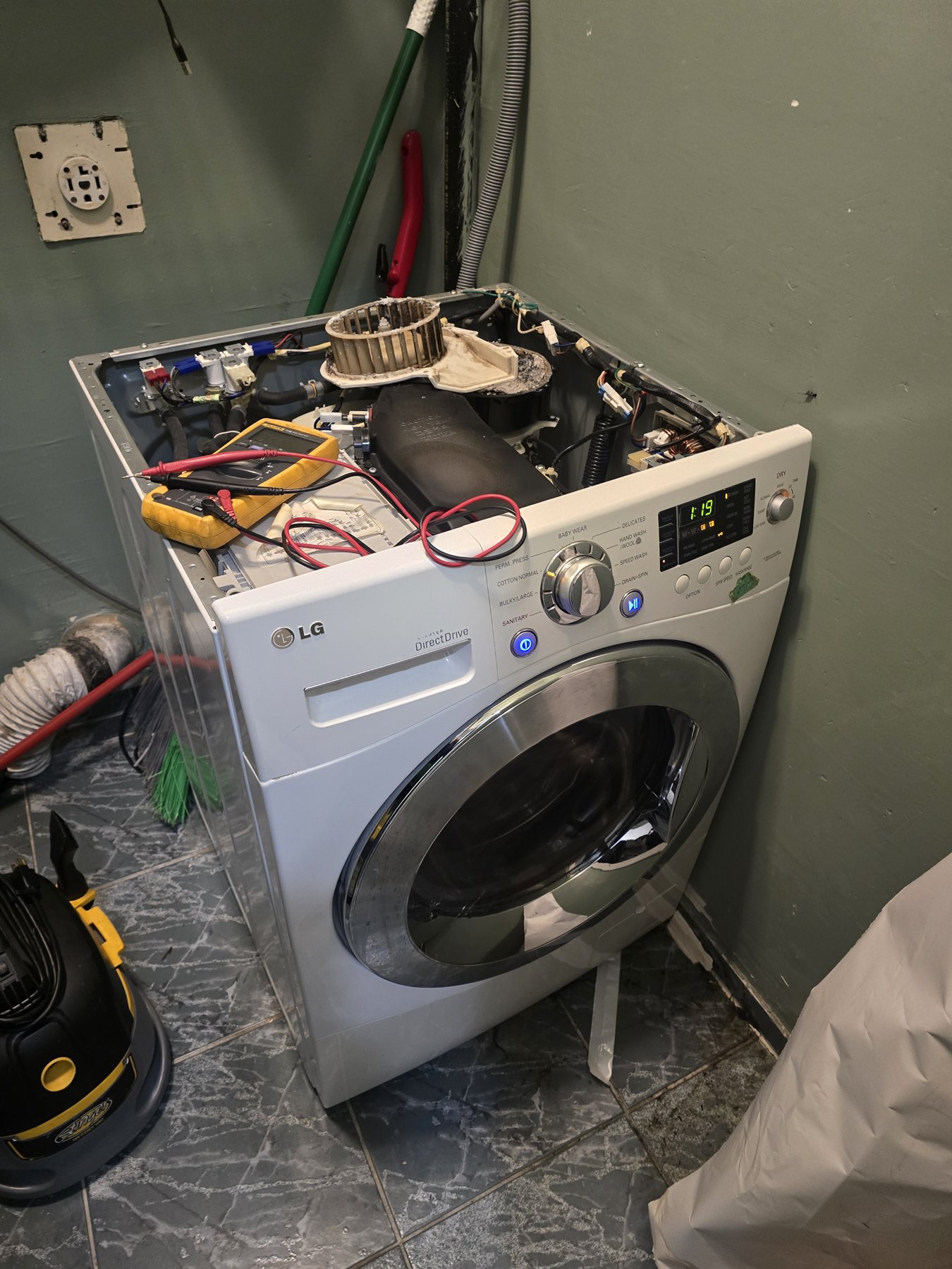 LG washer-dryer combo with its top panel removed during motor replacement in Toronto