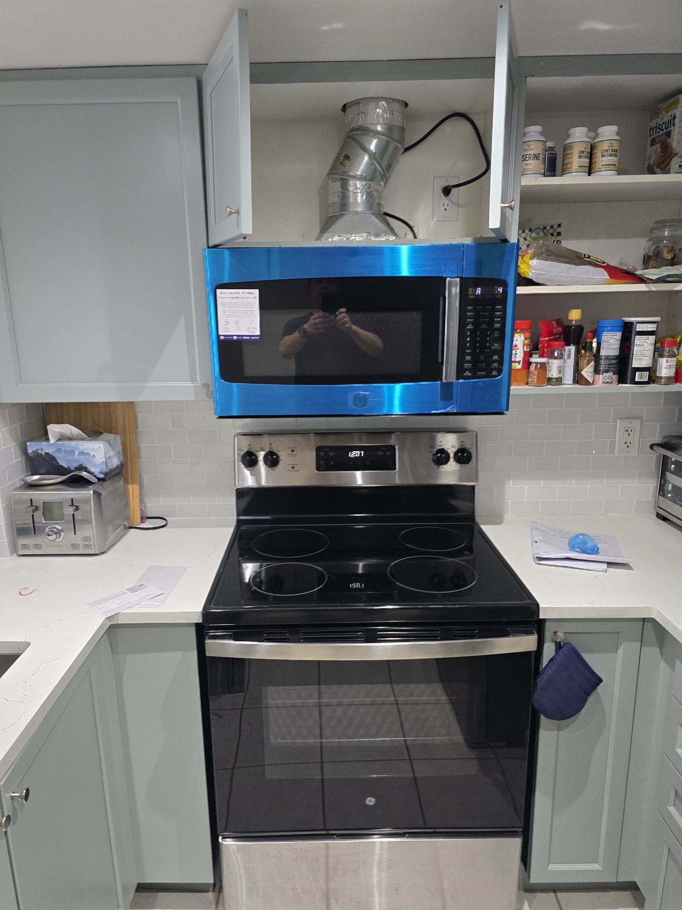 GE over-the-range microwave mounted above an electric range in a Toronto kitchen