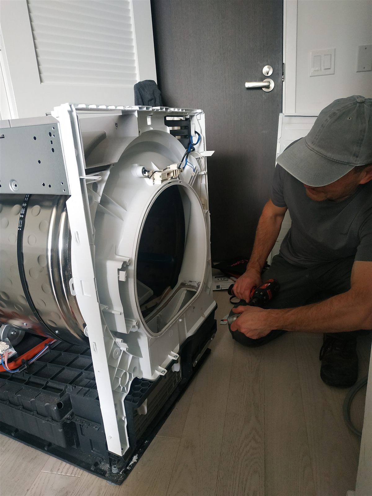 Appliance Trust technician repairing an open front-load washing machine